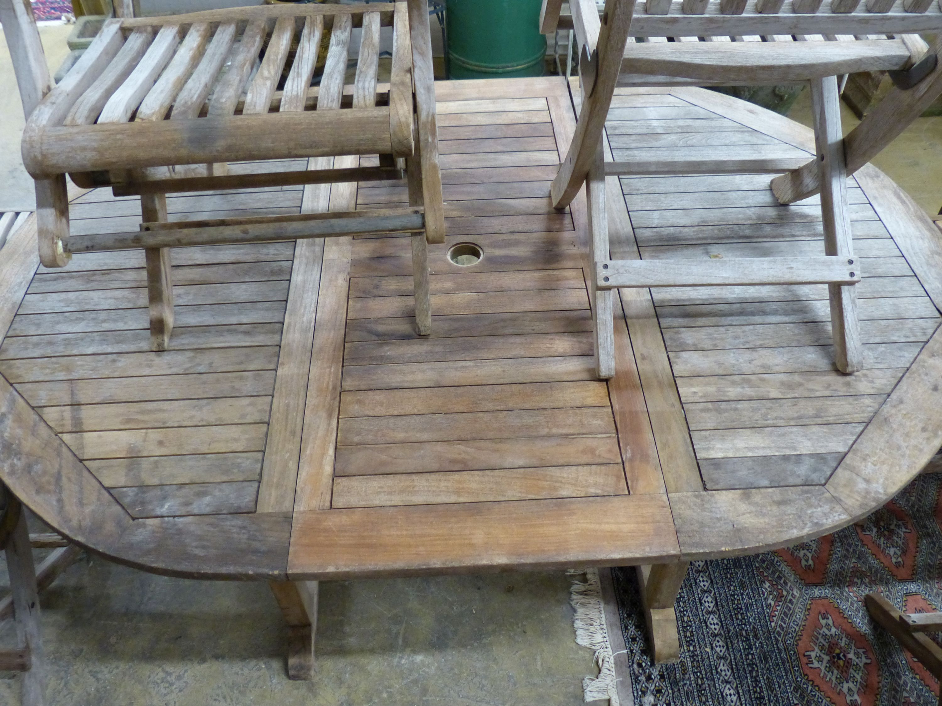 A 'Westminster' extending teak garden table, length 171cm and a set of six folding chairs